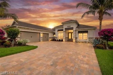 Contemporary single-story residence with a multi-car garage, featuring a stone veneer facade and a paver driveway