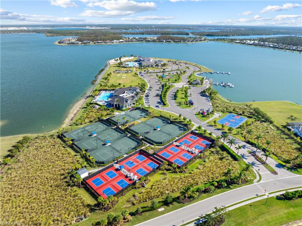 Expansive waterfront community featuring multiple tennis courts, pickleball courts, a basketball court, a large swimming pool, and a private marina with boat slips