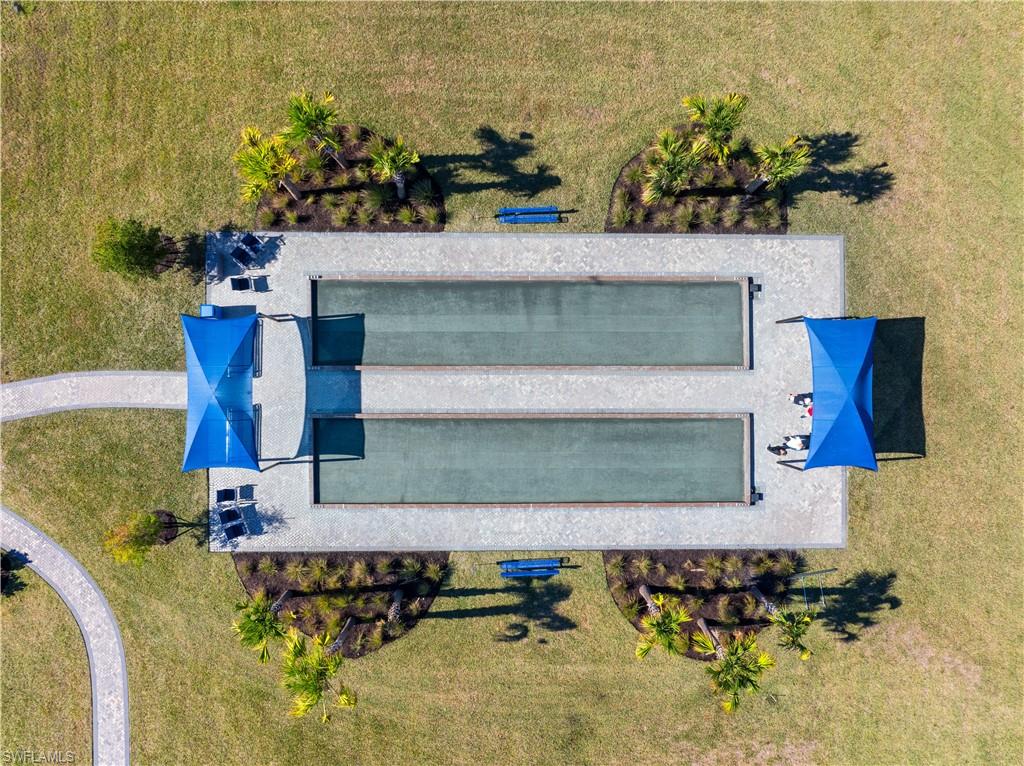 Recreational bocce ball courts featuring a paved surround and two shaded seating areas