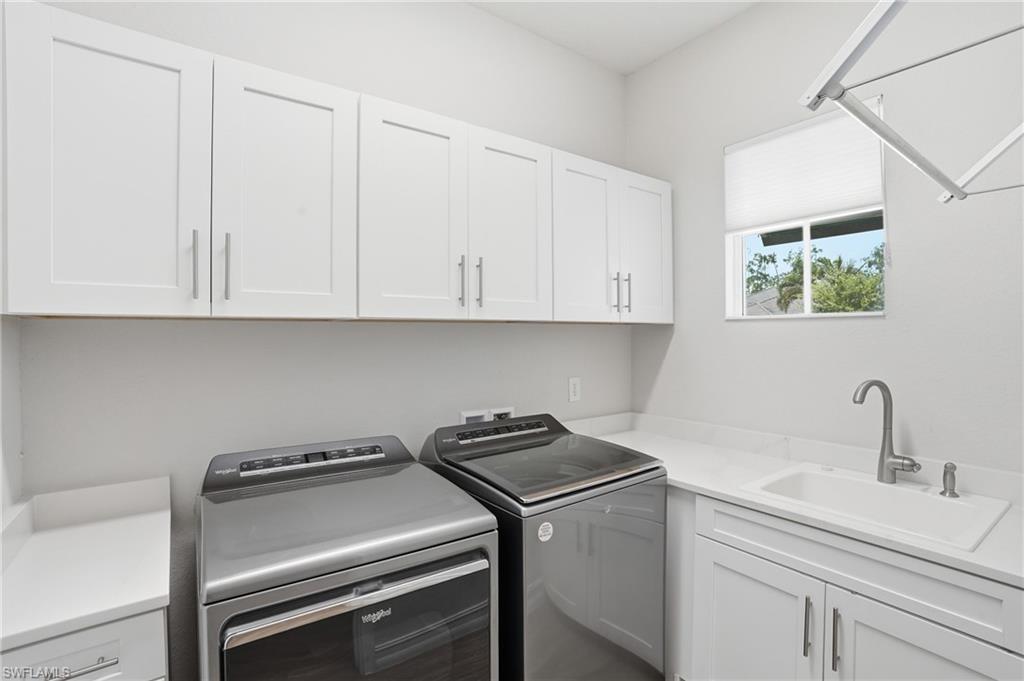 Laundry room featuring white shaker cabinetry, light countertops, a utility sink with a gooseneck faucet, and a window with natural light