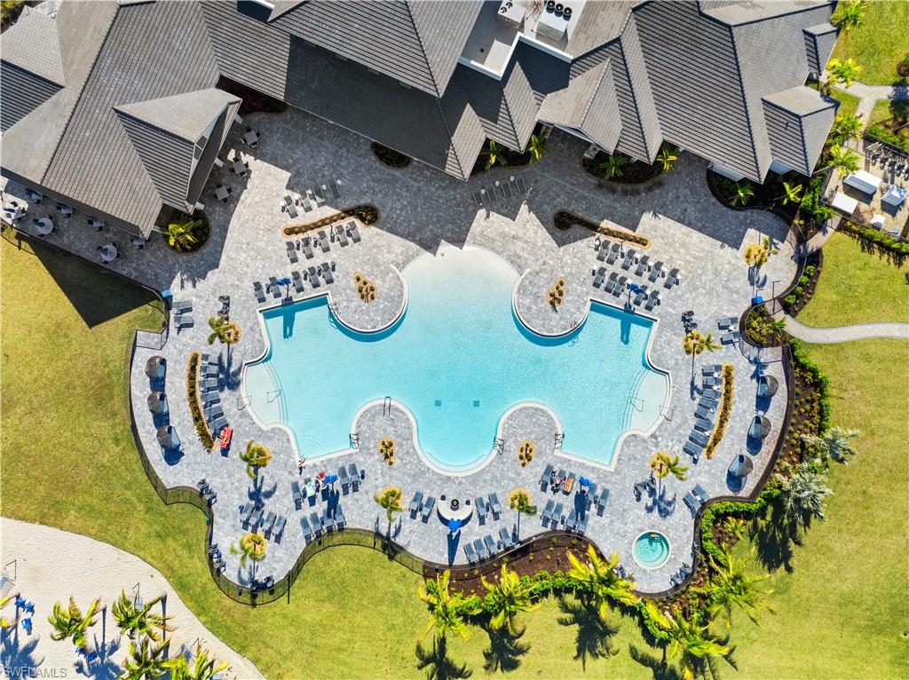 Expansive resort-style swimming pool featuring a sculpted perimeter, integrated spa, and surrounding paver deck