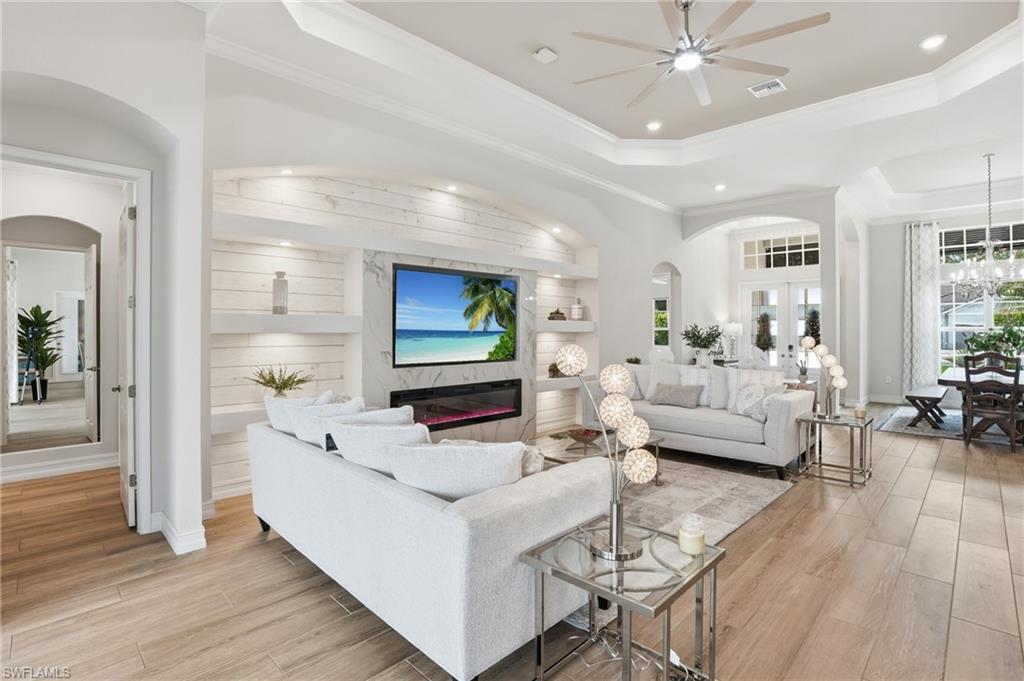 Spacious living area featuring light wood-finish flooring and a built-in media center with shiplap-style paneling and accent lighting