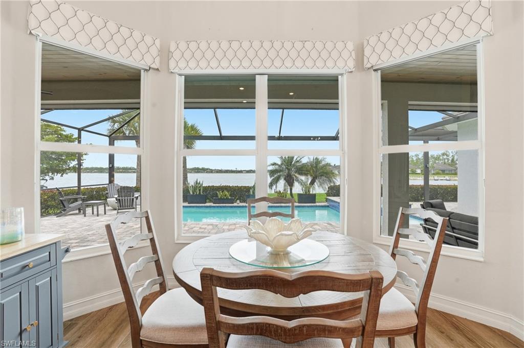 Dining area with bay window offering expansive water and pool access