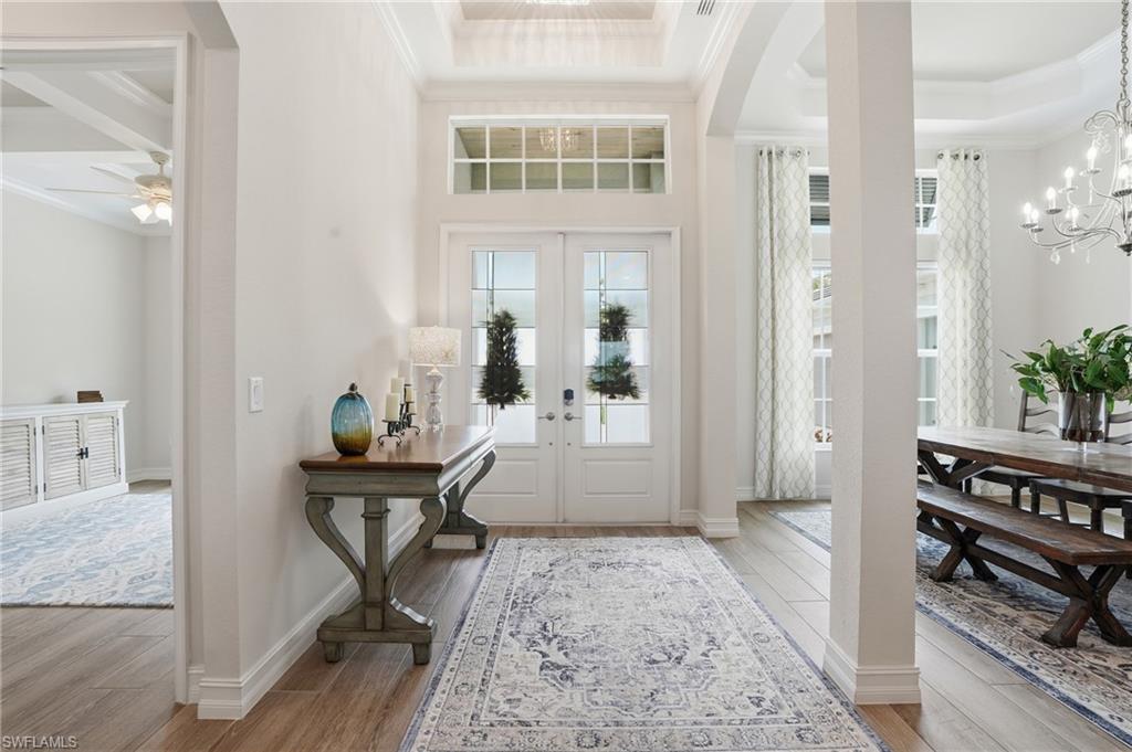 Foyer featuring double entry doors with glass panels, transom windows, and wood-finish flooring