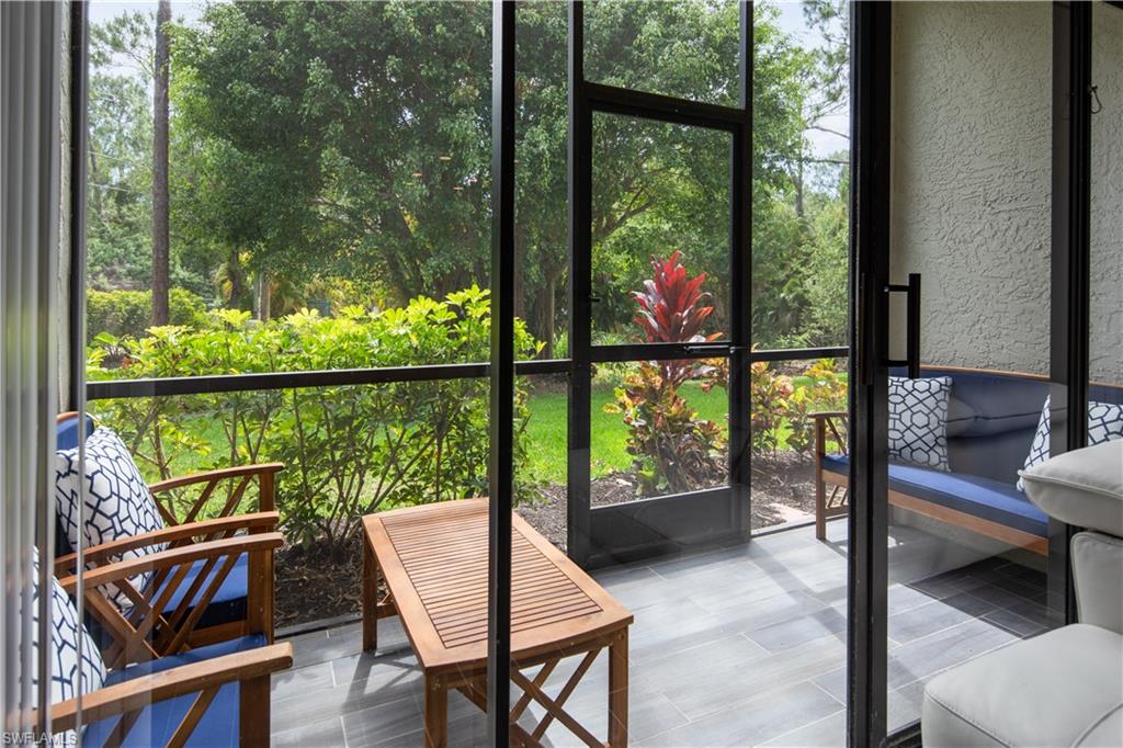 Screened patio featuring gray tile flooring and a lush green backdrop