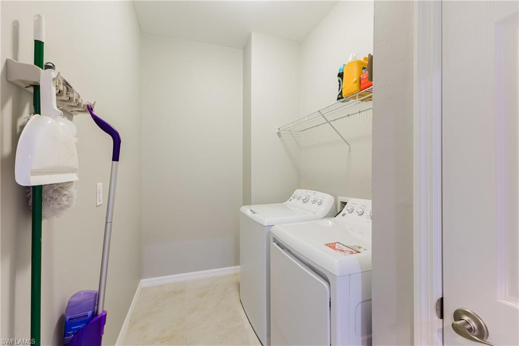 Laundry room featuring washer and dryer and light tile patterned flooring