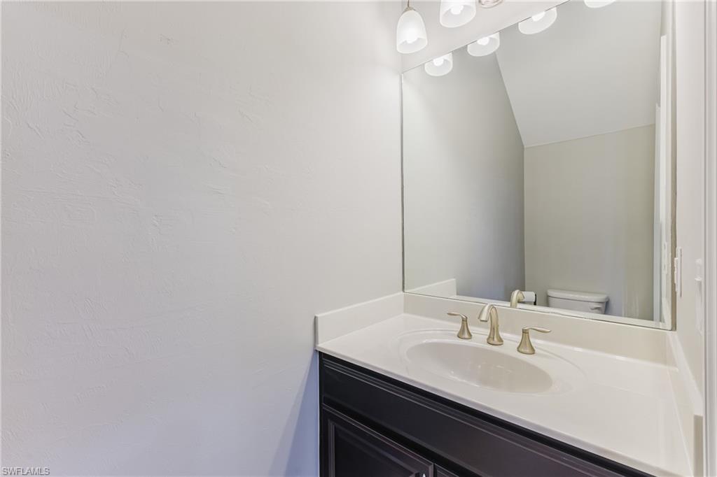 Bathroom with vanity and lofted ceiling
