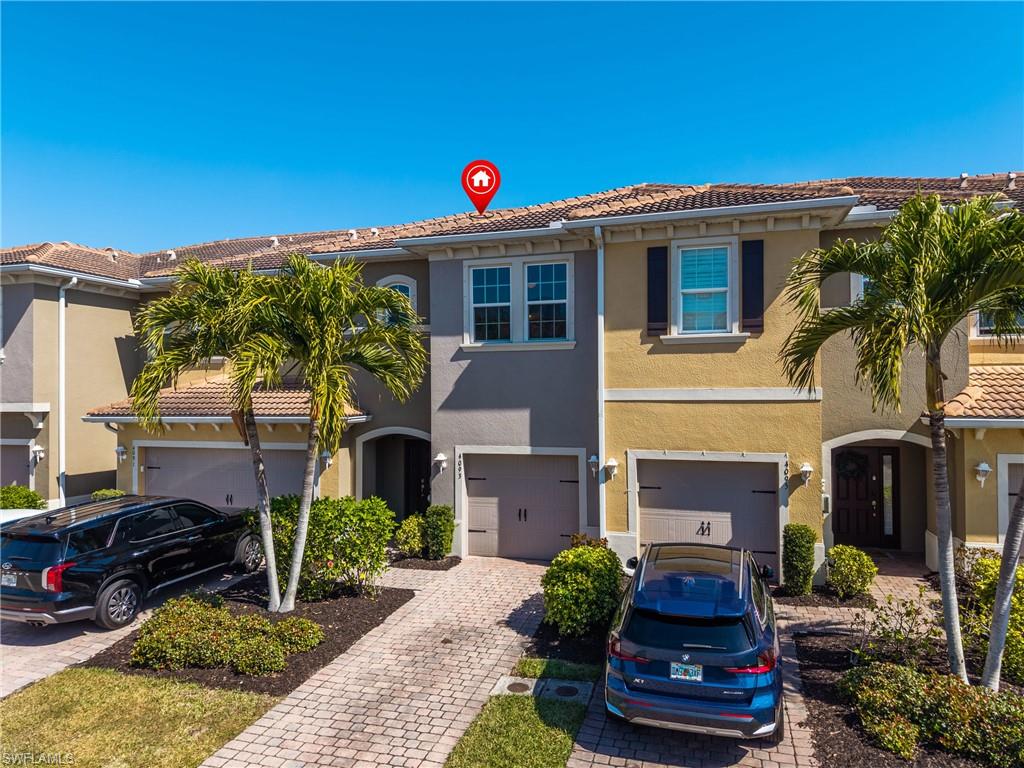 Mediterranean / spanish-style house featuring an attached garage, stucco siding, and driveway