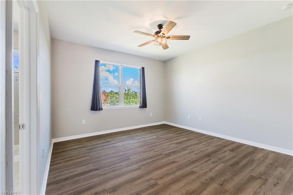 Spare room with dark wood finished floors and ceiling fan