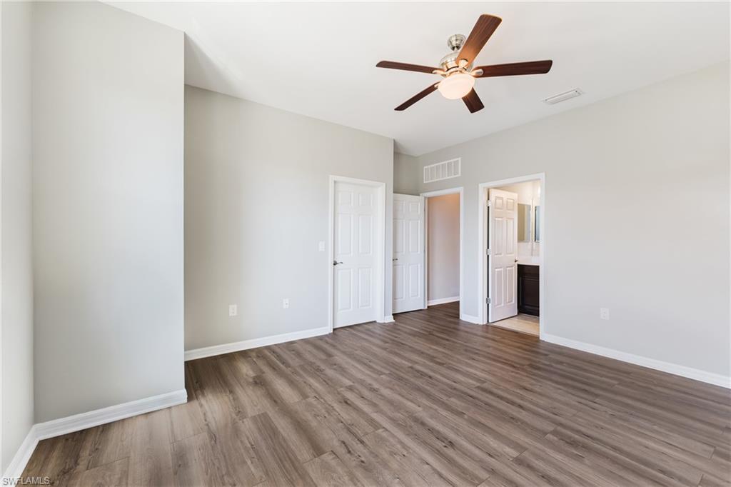 Unfurnished bedroom with light wood finished floors, ceiling fan, and connected bathroom