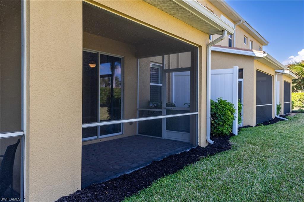 View of home's exterior featuring stucco siding, a sunroom, and a yard