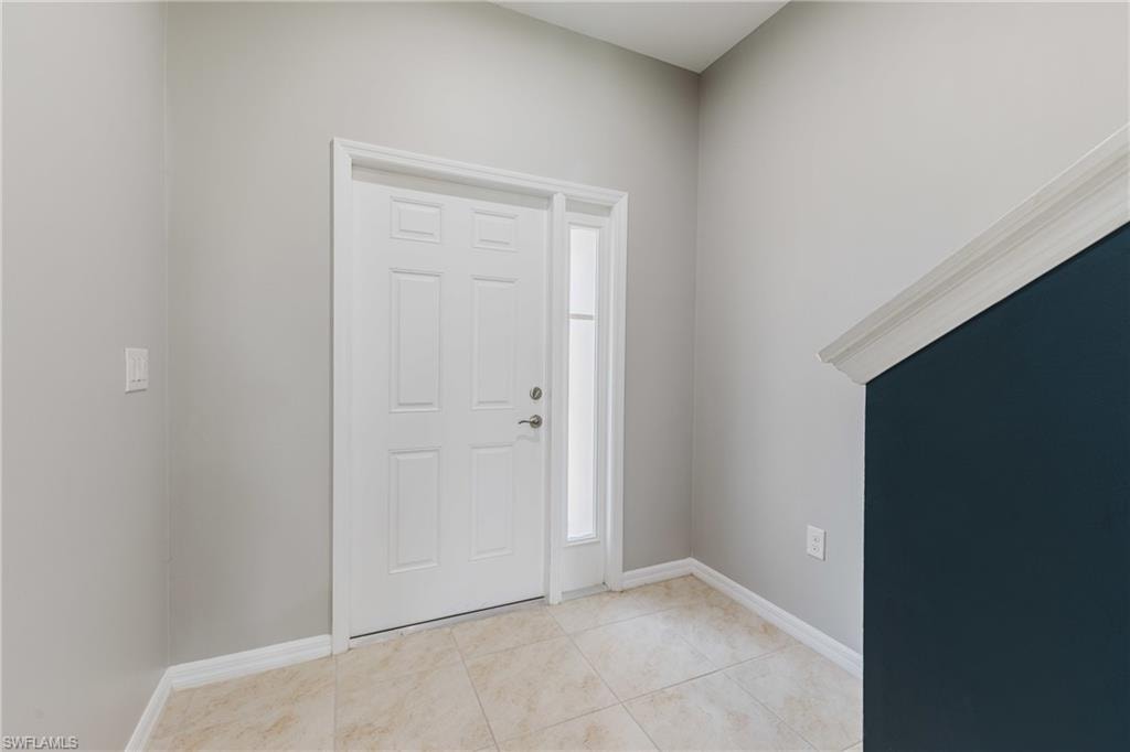 Entrance foyer with baseboards and light tile patterned floors