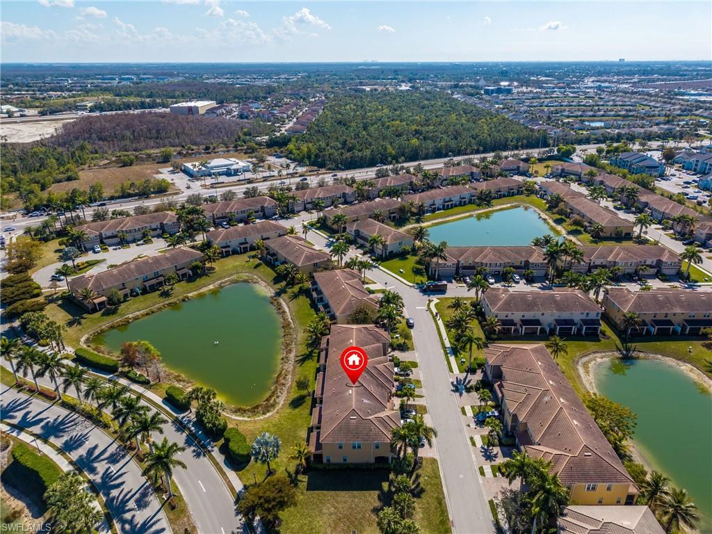 Aerial view of property and surrounding area with a nearby body of water and nearby suburban area