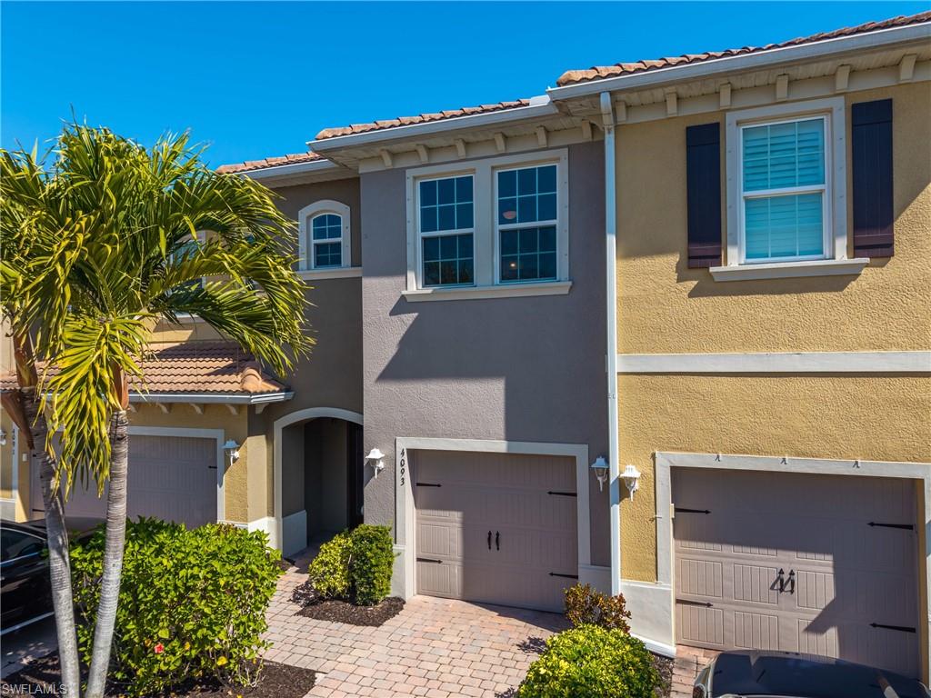Mediterranean / spanish-style home with a garage, stucco siding, and a tiled roof