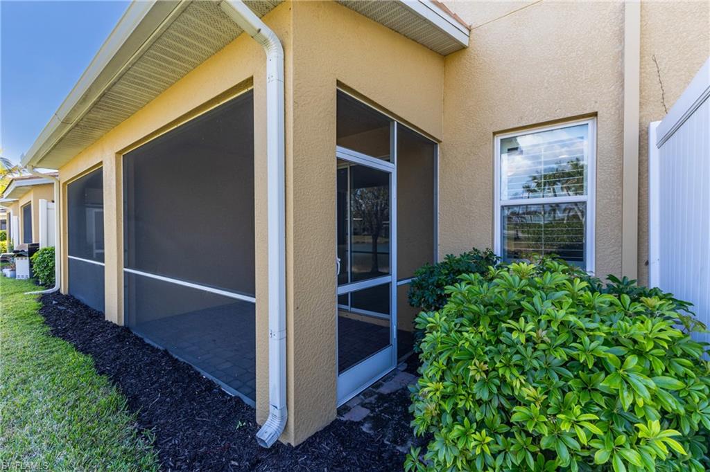 View of side of home with a sunroom and stucco siding