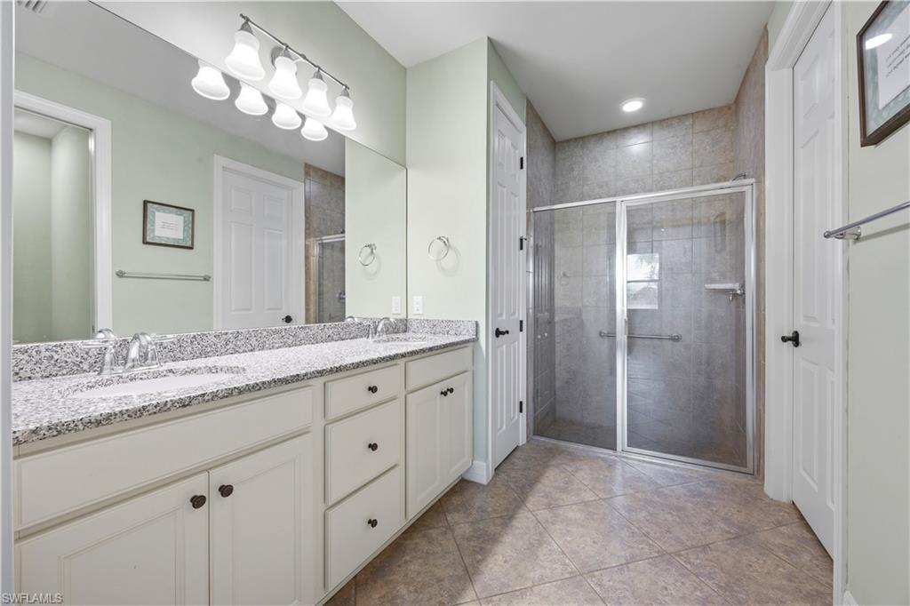 Primary bathroom featuring a dual vanity and white cabinetry