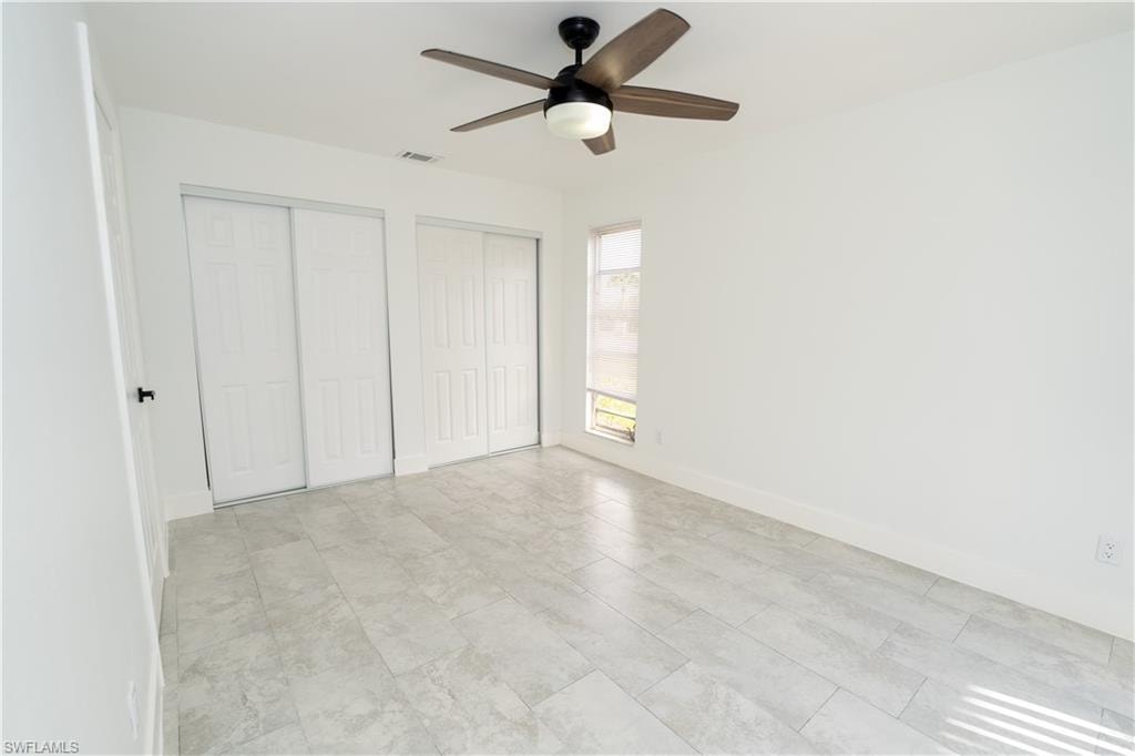 Bright interior space featuring light-toned tile flooring and white baseboards