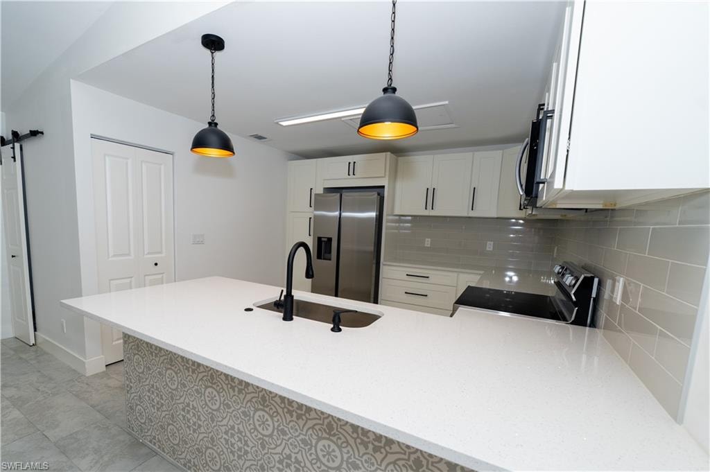 Kitchen island with a white solid surface countertop and undermount sink