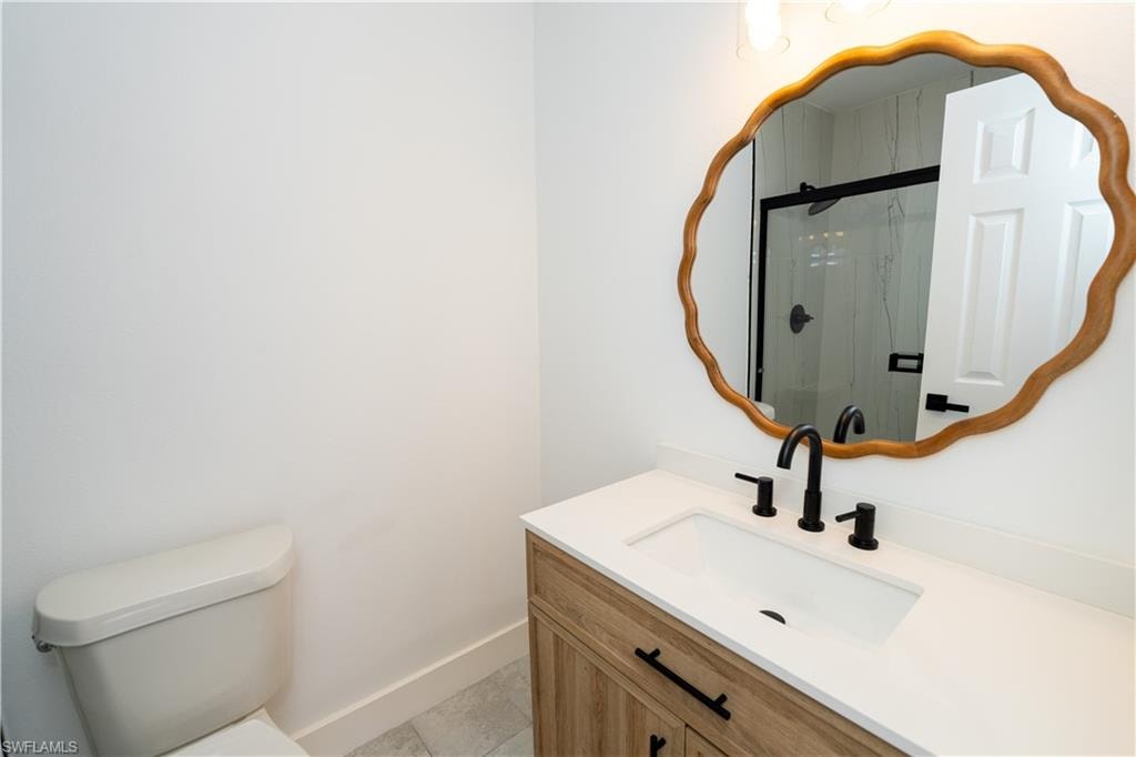 Bathroom featuring a single vanity with wood-finish cabinetry, a white countertop, and a rectangular undermount sink