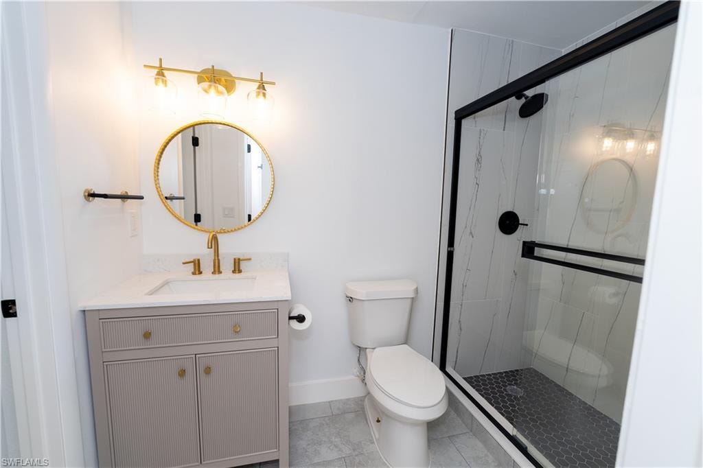 Bathroom featuring a walk-in shower with black-framed glass enclosure, white marble-look shower surround, and black hexagonal tile floor