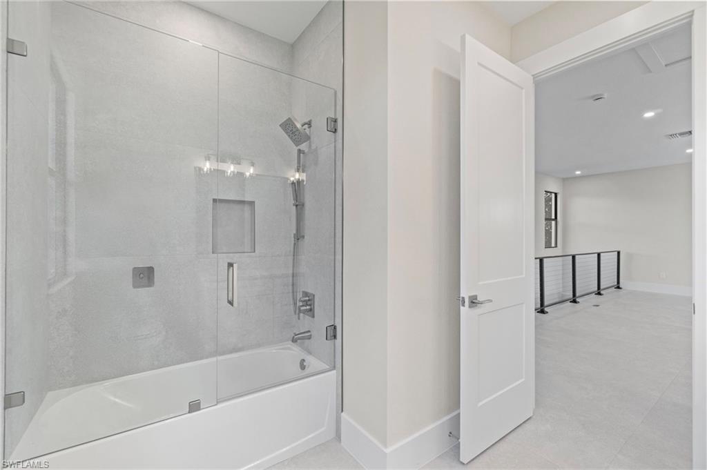 Full bath featuring combined bath / shower with glass door, recessed lighting, and tile patterned floors