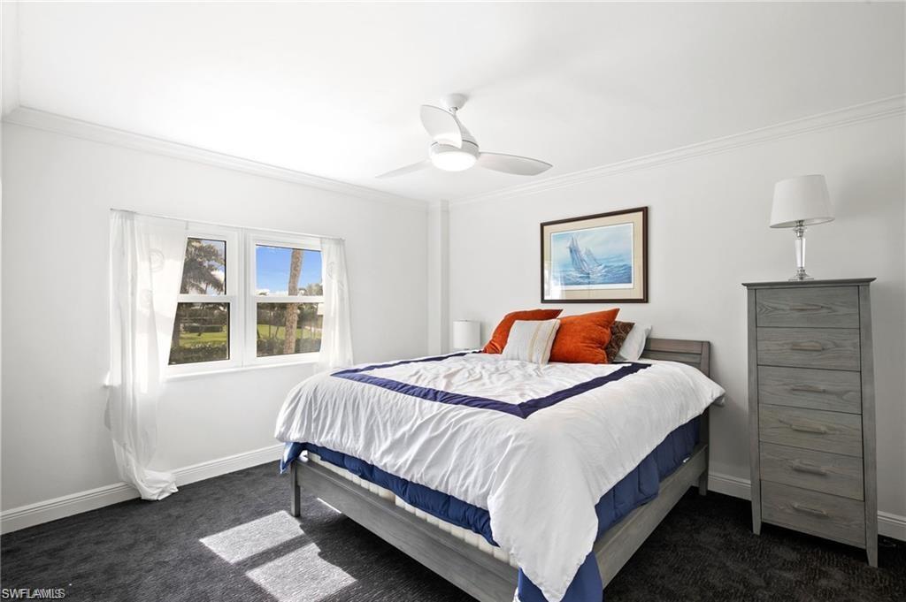 Carpeted bedroom featuring ornamental molding and ceiling fan