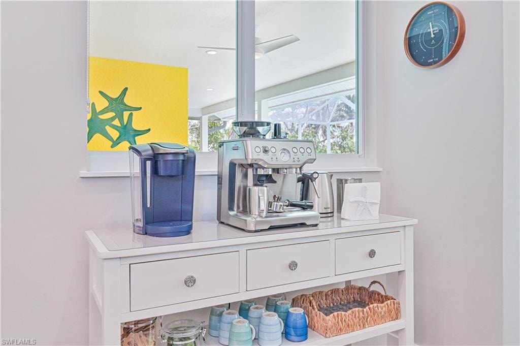 White console table with three drawers featuring decorative knobs, a lower open shelf, and a light-colored top surface