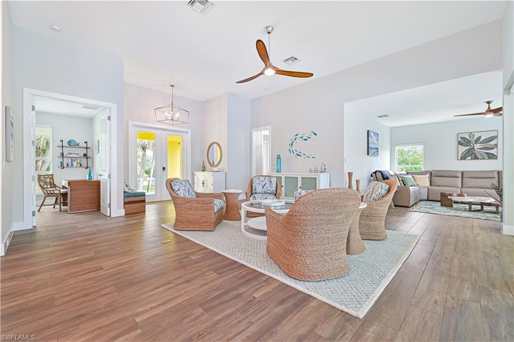 Open-concept living space featuring wood-finish flooring, vaulted ceilings, and a contemporary ceiling fan