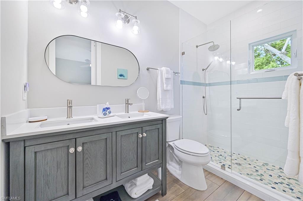 Modern bathroom featuring a dual vanity with a gray wood-finish cabinet, white countertop, and rectangular undermount sinks
