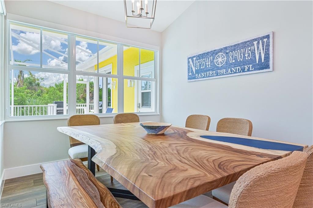 Dining area featuring a large window, white trim, recessed lighting, and wood-finish flooring