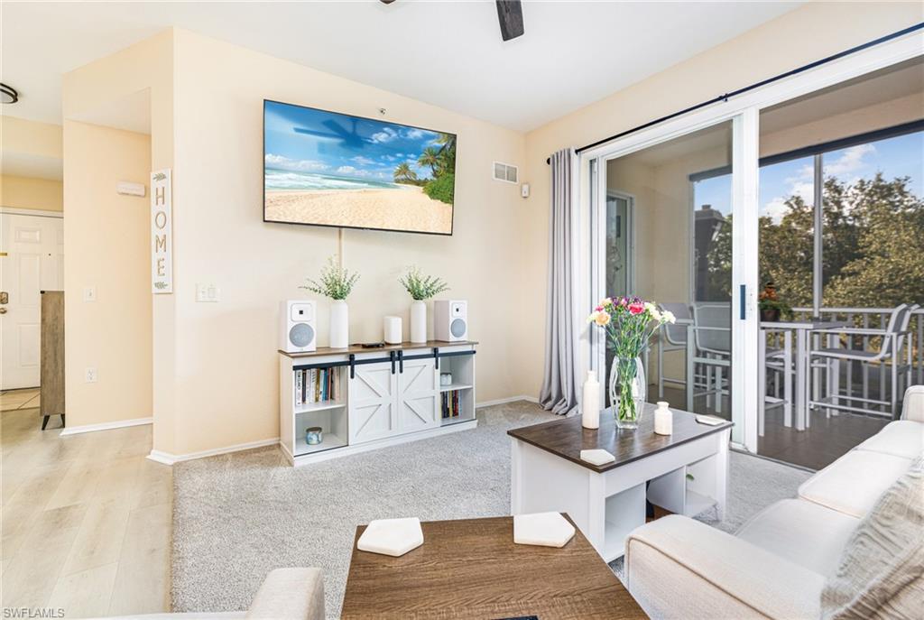Living area with sliding glass doors opening to a screened balcony