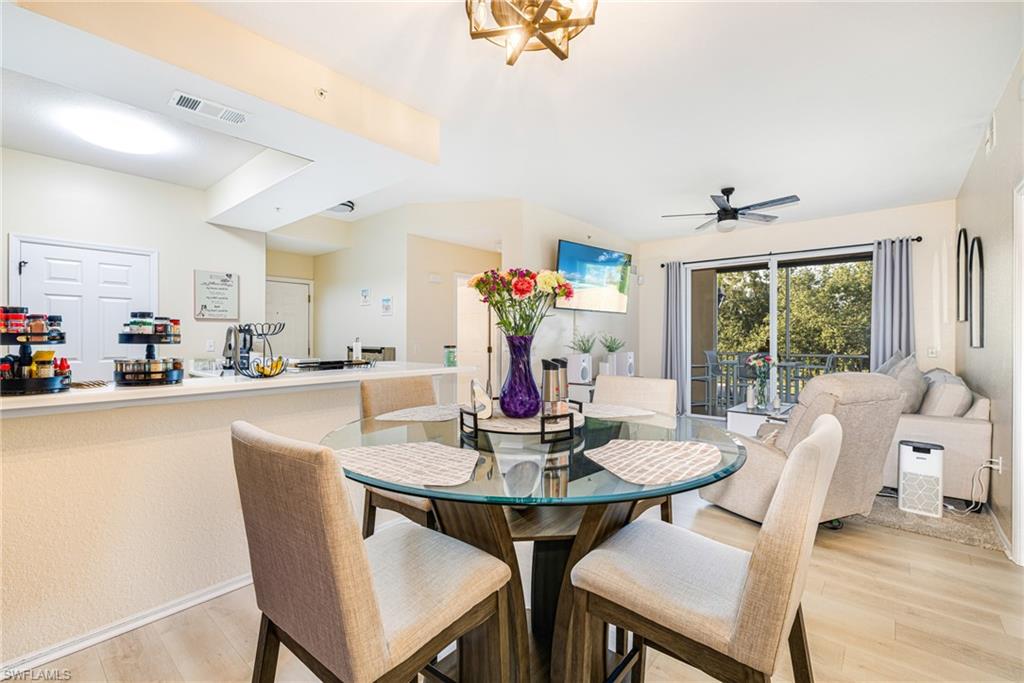 Open concept living area featuring wood-finish flooring, a ceiling fan, and a sliding glass door leading to an outdoor space