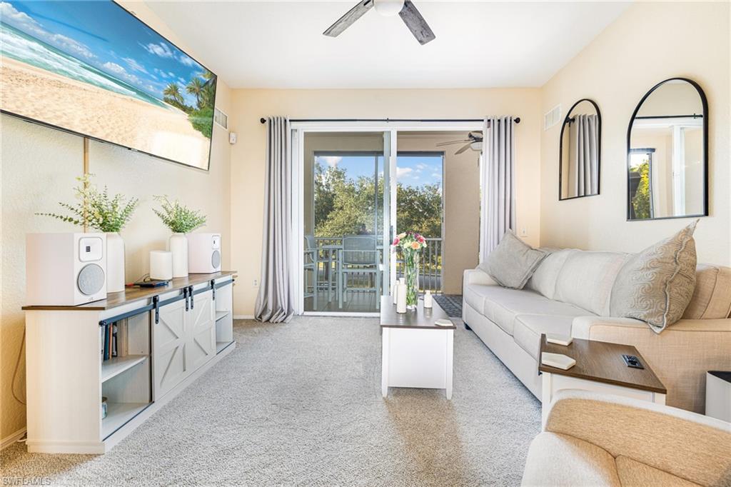Spacious living area featuring light-toned carpeting and neutral wall tones