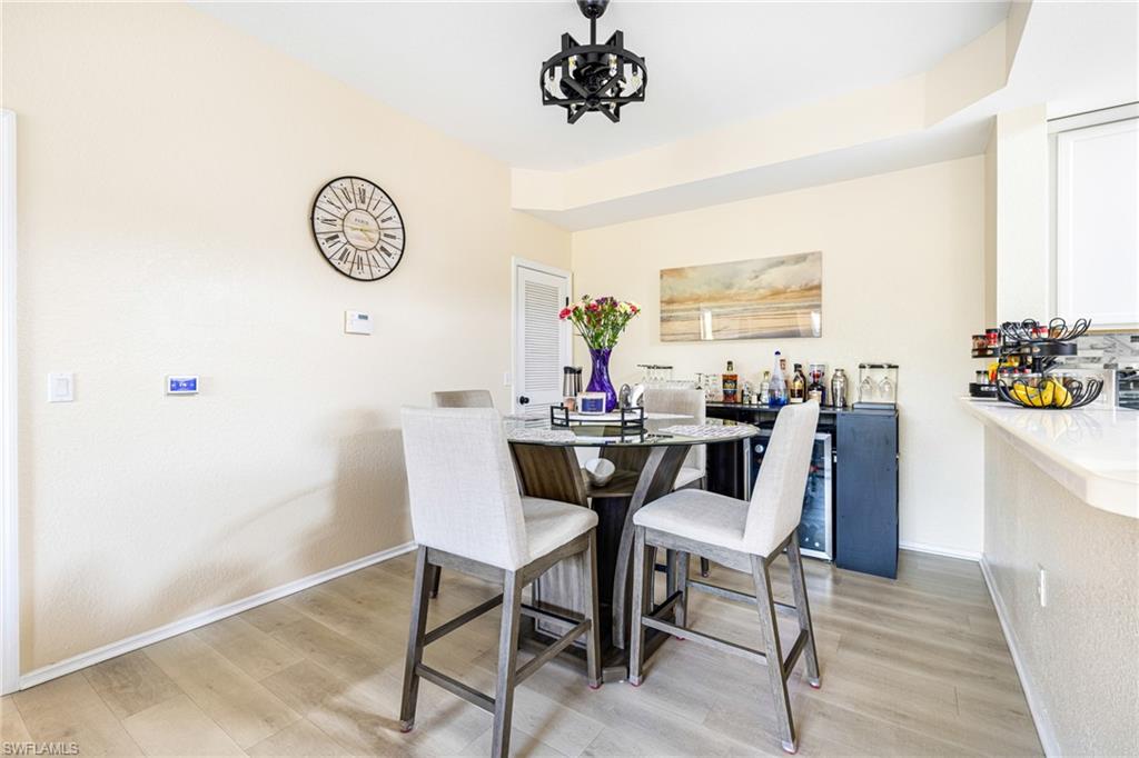 Dining area with wood-finish flooring and a contemporary black ceiling fixture