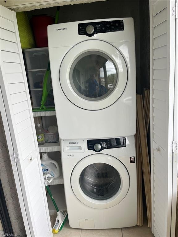 Laundry room with stacked washer and dryer, laundry area, and tile patterned flooring