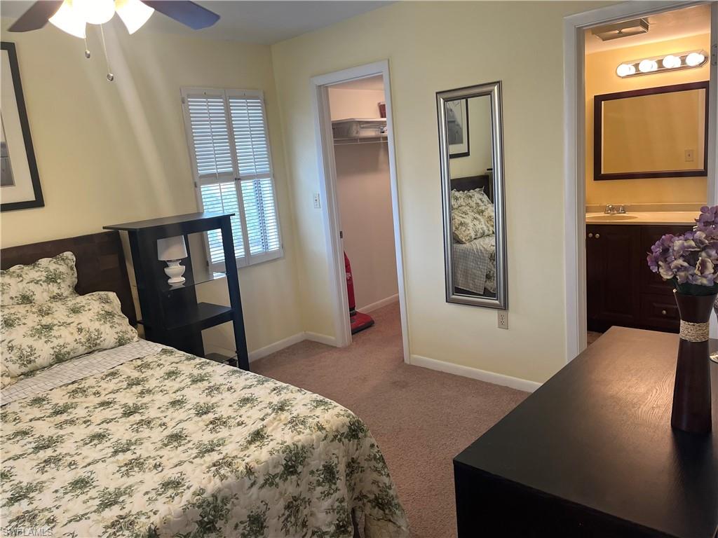 Carpeted bedroom featuring connected bathroom, a sink, a closet, baseboards, and a spacious closet