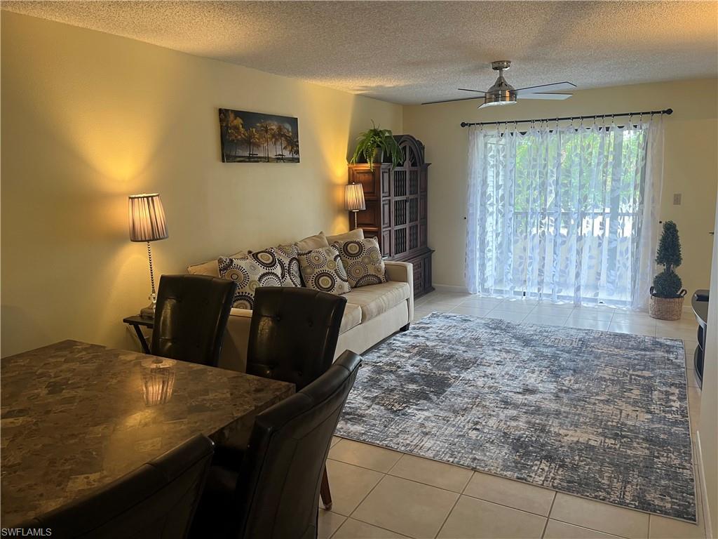 Tiled living room featuring a textured ceiling and ceiling fan