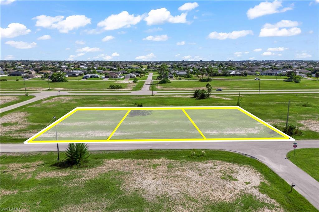 Expansive aerial shot showcasing all three adjoining parcels totaling 0.70 acres — an impressive amount of land in one of NW Cape Coral’s most desirable up-and-coming areas.