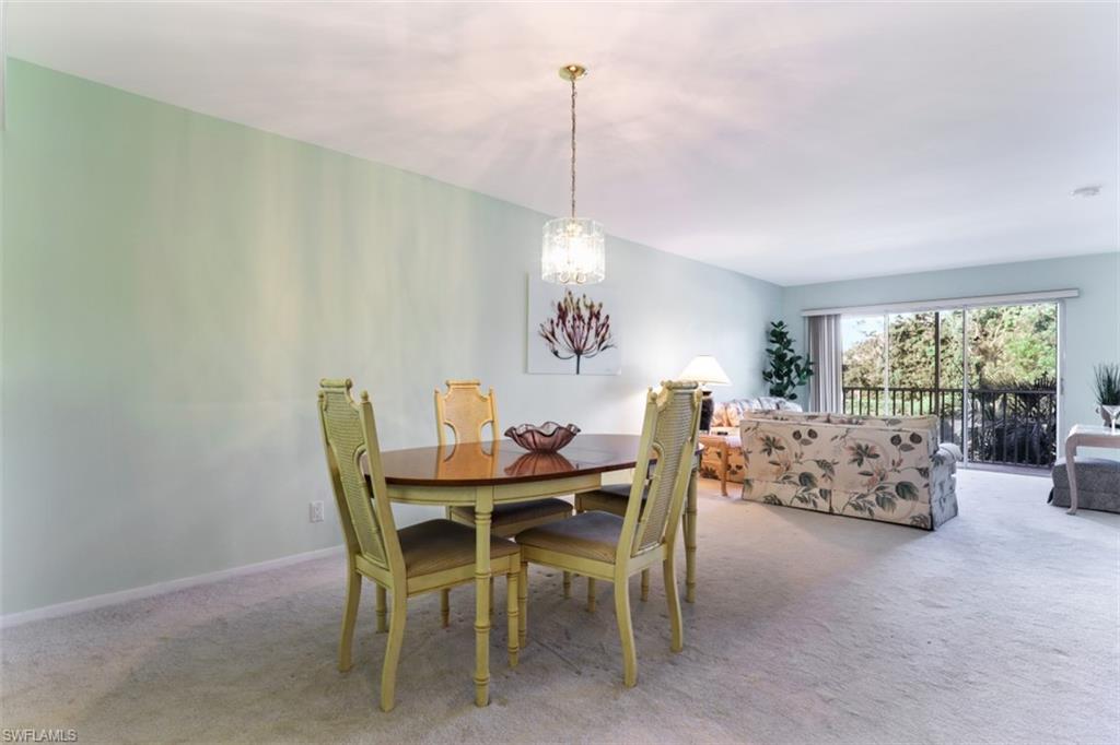 Carpeted dining space featuring a notable chandelier