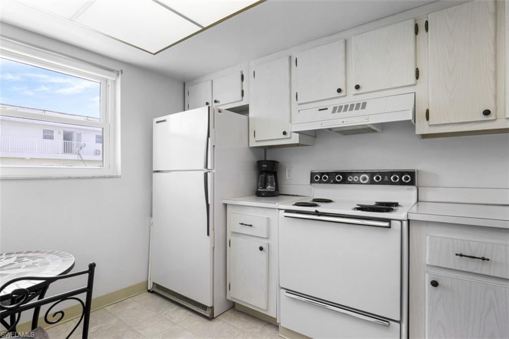 Kitchen with white appliances and light tile patterned floors