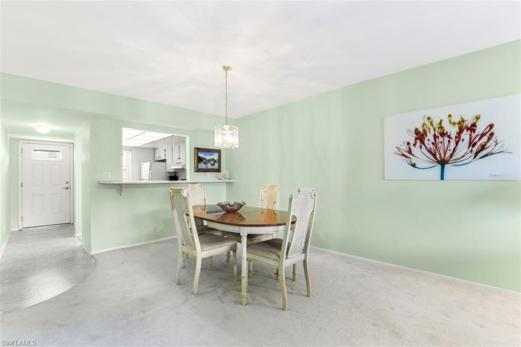 Carpeted dining space featuring a chandelier