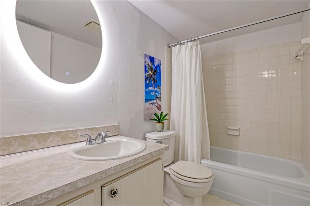 Full bathroom with vanity, tile patterned floors, shower / bath combo, and toilet