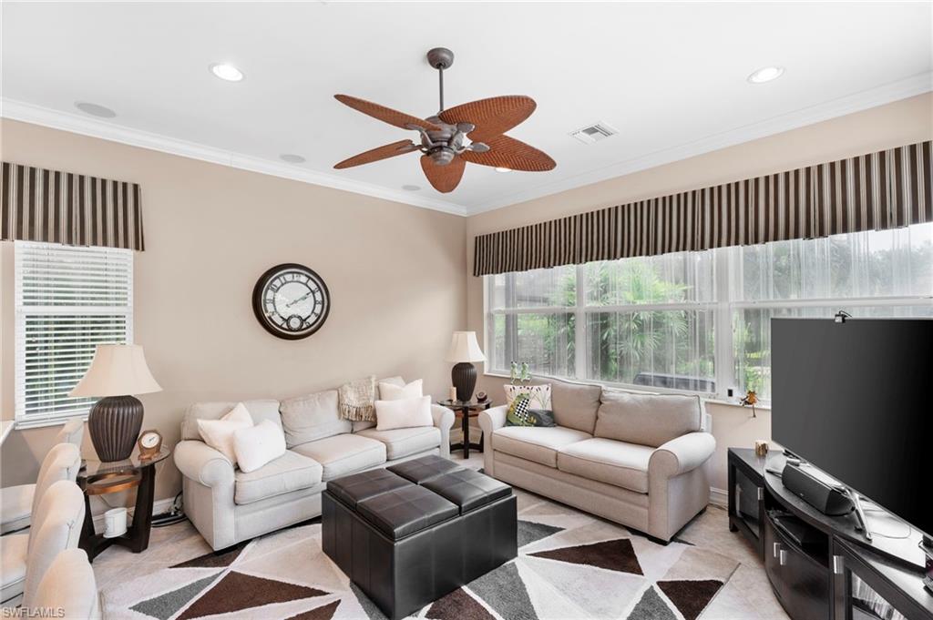 Living room featuring crown molding and ceiling fan