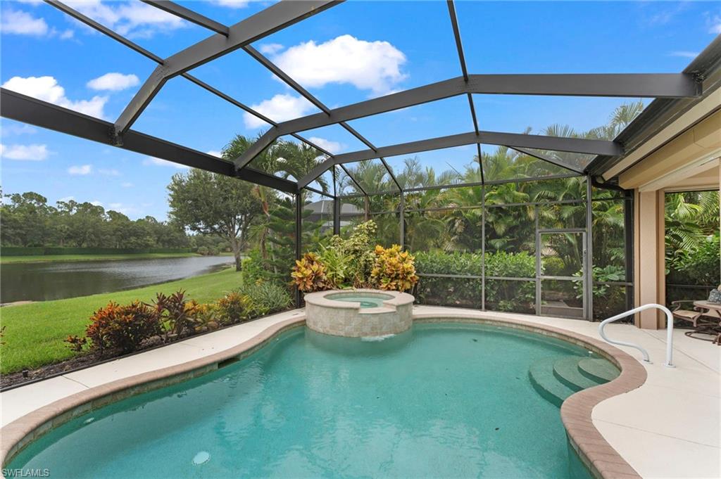 View of pool with an in ground hot tub, a water view, and a lanai