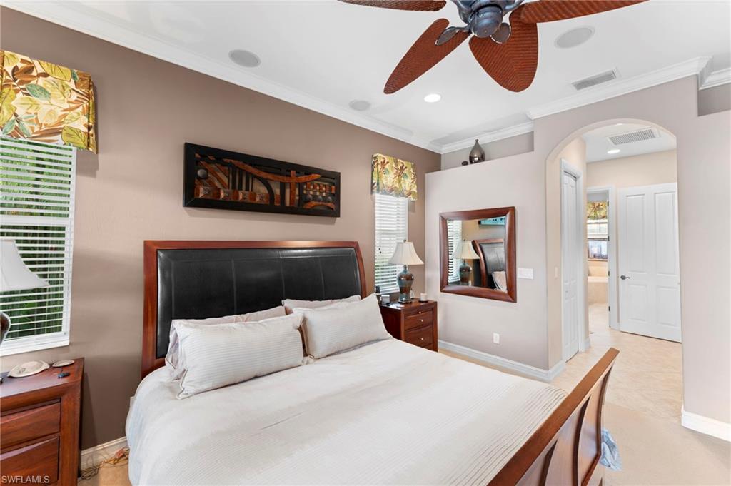 Bedroom with ornamental molding, multiple windows, light tile patterned floors, and ceiling fan