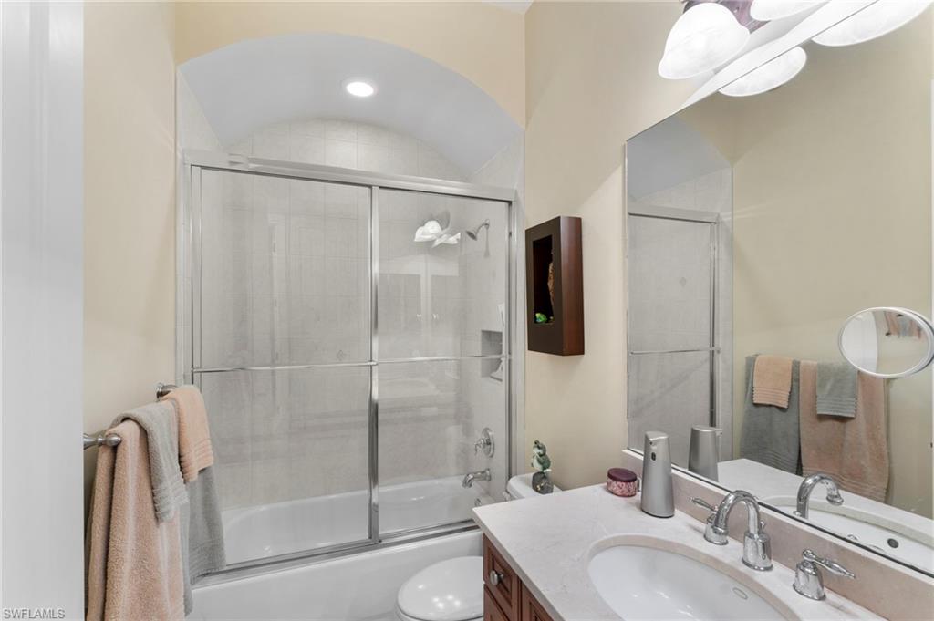 Full bathroom with vanity, enclosed tub / shower combo, and toilet