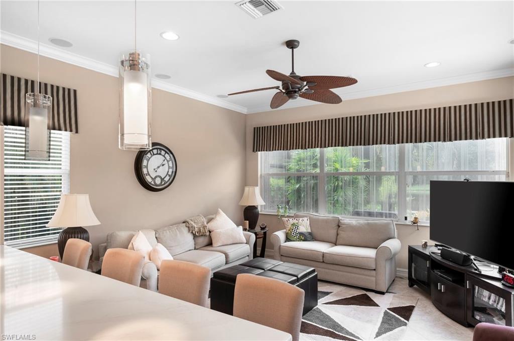Living room with crown molding and ceiling fan