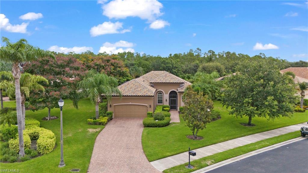 Mediterranean / spanish home featuring a garage and a front lawn