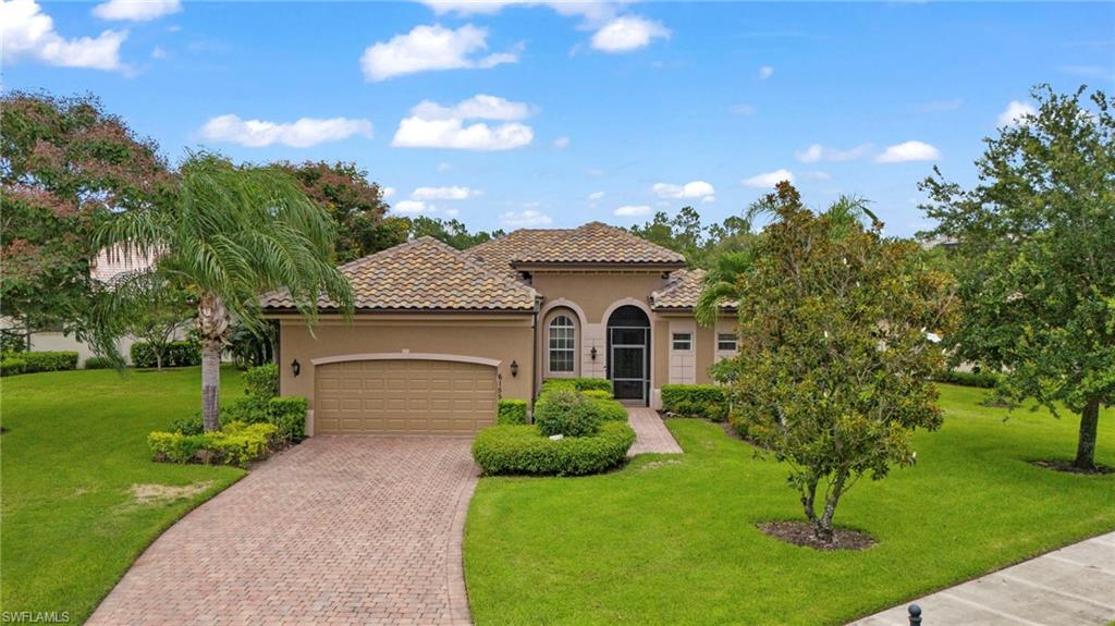 Mediterranean / spanish-style house with a garage and a front lawn