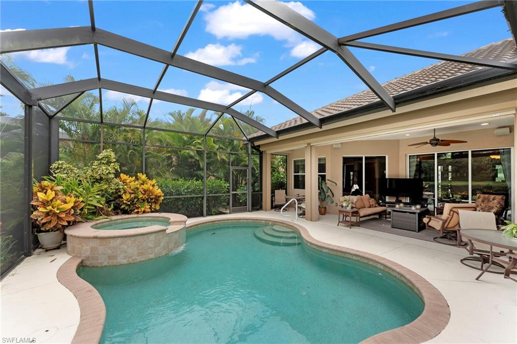 View of pool featuring an in ground hot tub, a lanai, a patio area, and an outdoor living space
